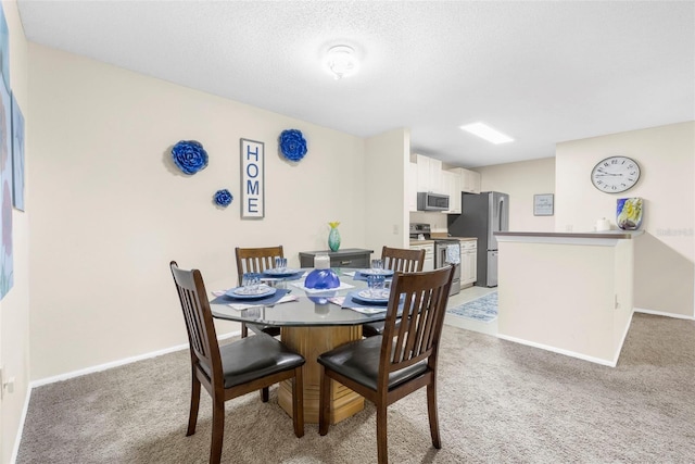 carpeted dining area featuring a textured ceiling