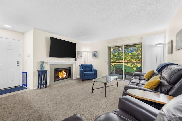 living room featuring a tiled fireplace, light carpet, and a textured ceiling