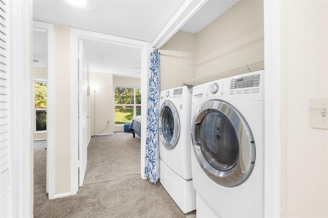 laundry room featuring separate washer and dryer and light colored carpet