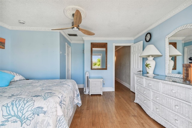 bedroom featuring ceiling fan, crown molding, light hardwood / wood-style floors, and a textured ceiling