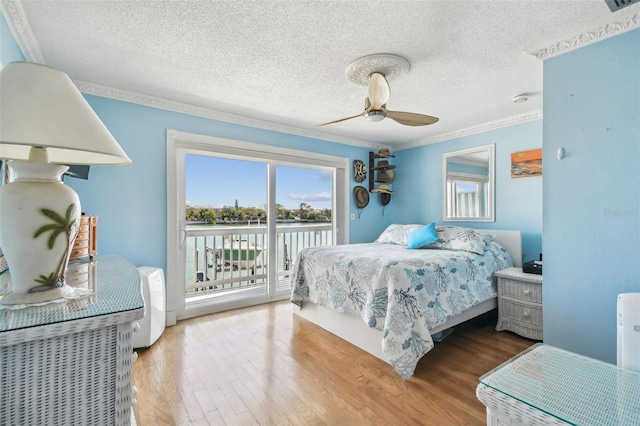 143 94th Ave Unit 2, Treasure Island, FL 33706 - bedroom featuring access to exterior, wood finished floors, a textured ceiling, ceiling fan, and crown molding