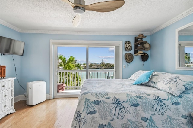 143 94th Ave Unit 2, Treasure Island, FL 33706 - bedroom with access to outside, wood finished floors, a water view, a textured ceiling, and ceiling fan