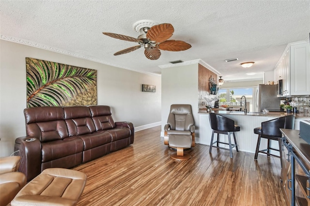 143 94th Ave Unit 2, Treasure Island, FL 33706 - living area featuring wood finished floors, a ceiling fan, a textured ceiling, and ornamental molding
