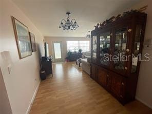 corridor with a notable chandelier and light hardwood / wood-style flooring