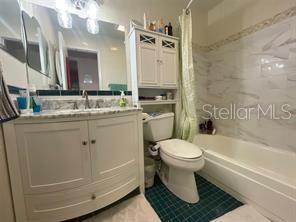 full bathroom featuring tile patterned flooring, shower / bath combo, toilet, and vanity