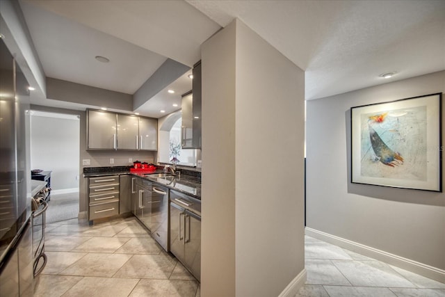 kitchen featuring dishwasher, light tile patterned floors, gray cabinetry, and sink