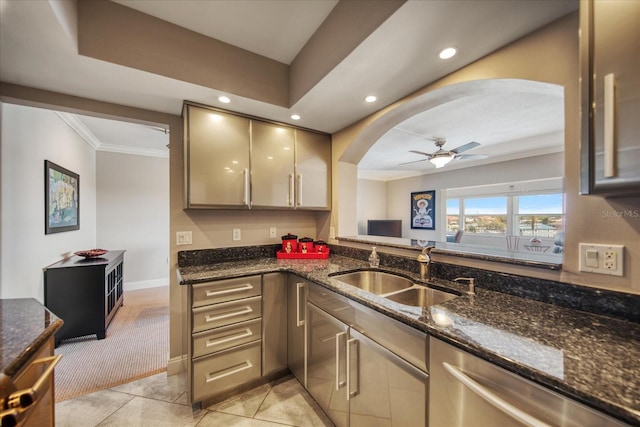 kitchen with ceiling fan, crown molding, sink, light tile patterned floors, and dark stone countertops