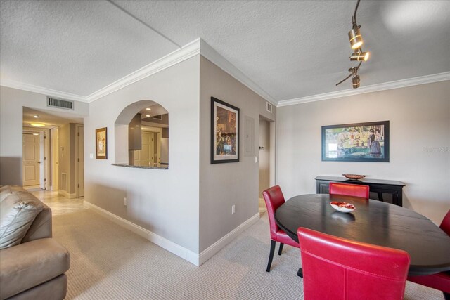 17400 Gulf Blvd Unit I5, Redington Shores, FL 33708 - carpeted dining area featuring ornamental molding, baseboards, a textured ceiling, and arched walkways