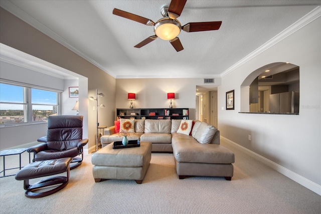 carpeted living room with crown molding and ceiling fan