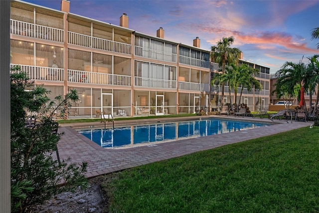 pool at dusk with a lawn