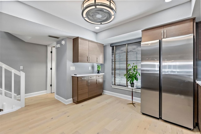 kitchen with stainless steel refrigerator and light hardwood / wood-style flooring