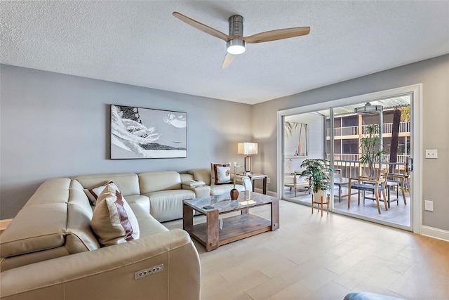 living room featuring a textured ceiling and ceiling fan