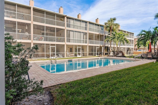 view of pool with a lawn and a patio area