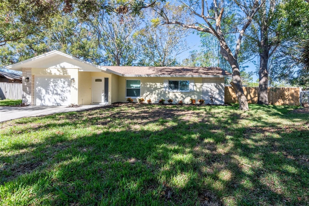 single story home featuring a front yard and a garage