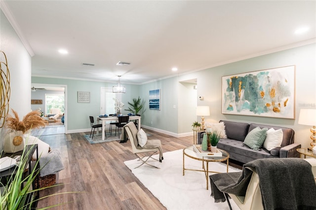 living room featuring crown molding and light hardwood / wood-style floors