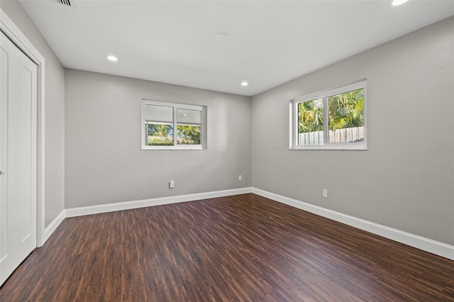 unfurnished room featuring plenty of natural light and dark hardwood / wood-style floors