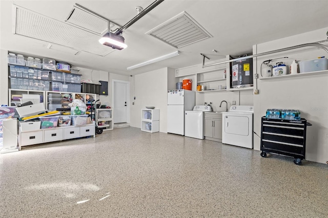 garage featuring a garage door opener, white refrigerator, and independent washer and dryer