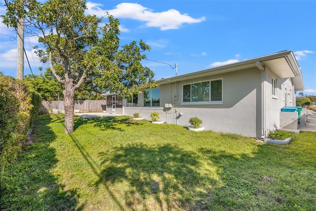 rear view of property featuring a sunroom and a yard