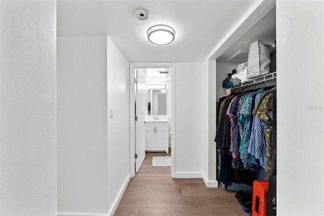 corridor featuring sink and light wood-type flooring