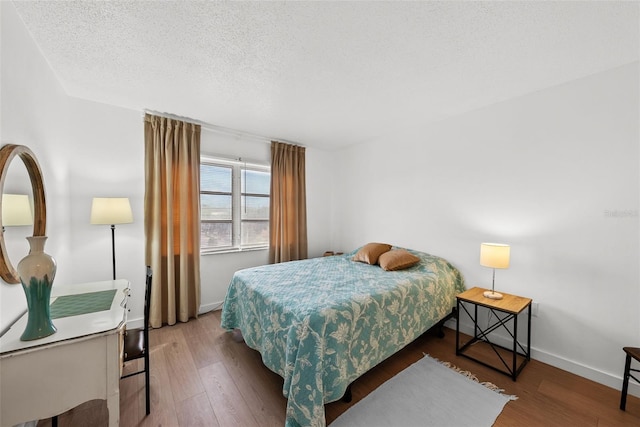 bedroom with hardwood / wood-style floors and a textured ceiling