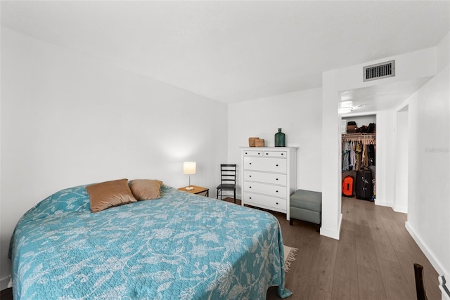 bedroom featuring hardwood / wood-style floors, a spacious closet, and a closet