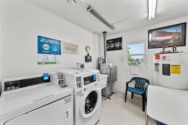 laundry area with electric water heater and washing machine and clothes dryer