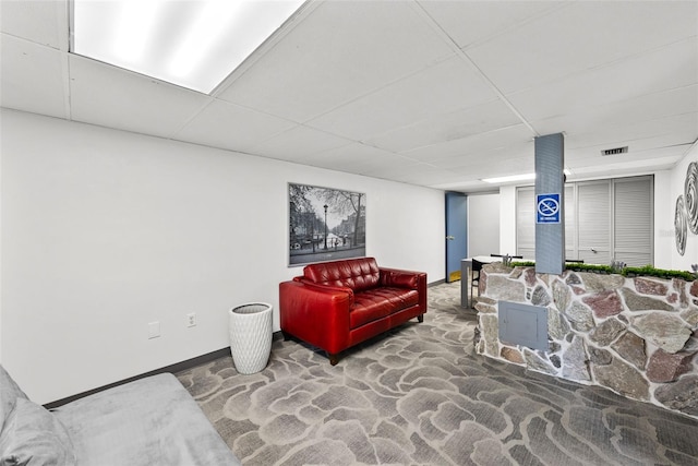 carpeted living room with a paneled ceiling