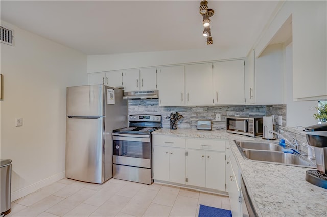 kitchen featuring white cabinetry, sink, backsplash, lofted ceiling, and appliances with stainless steel finishes