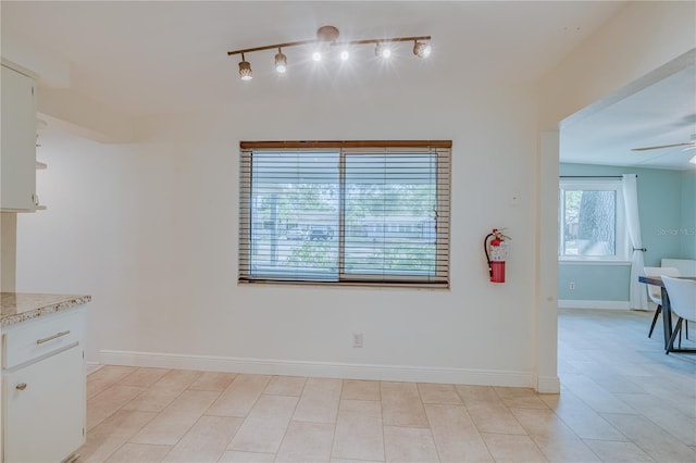 tiled dining space featuring ceiling fan and rail lighting