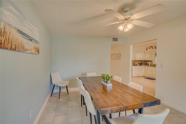 tiled dining space featuring ceiling fan