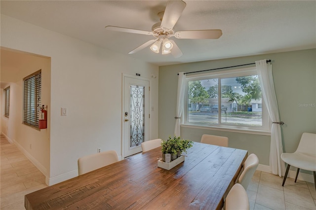 tiled dining space with ceiling fan