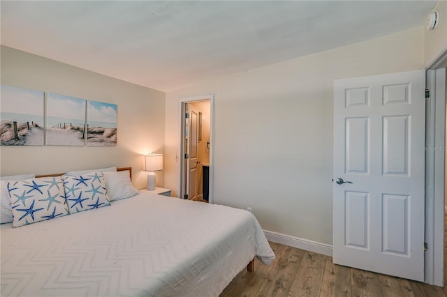 bedroom featuring connected bathroom and hardwood / wood-style flooring