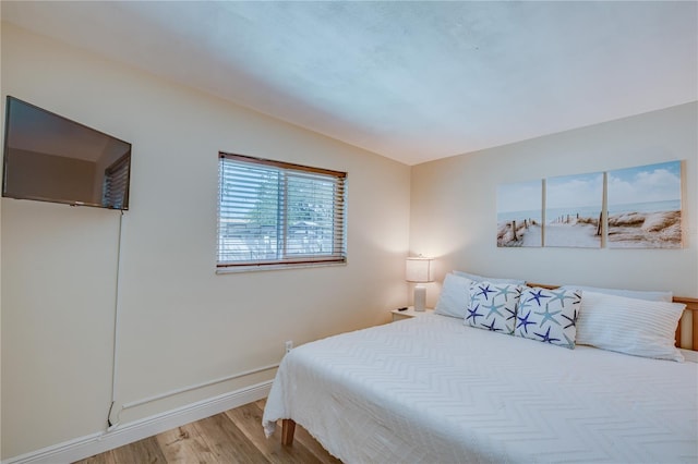 bedroom with wood-type flooring and lofted ceiling