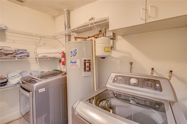 laundry room with cabinets, independent washer and dryer, and water heater