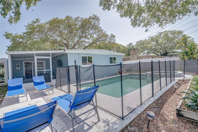 view of swimming pool featuring a patio area and a sunroom