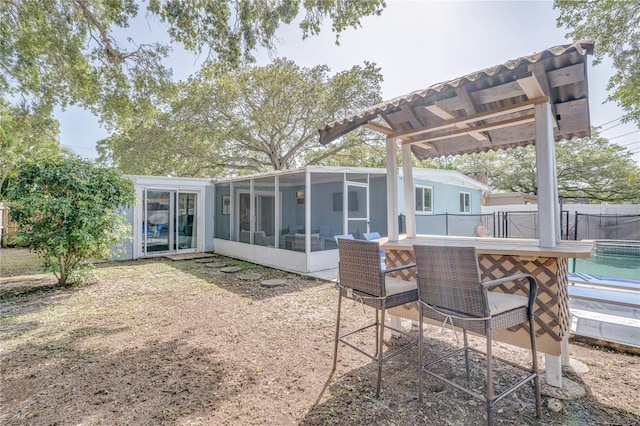 back of house featuring a sunroom and a pool