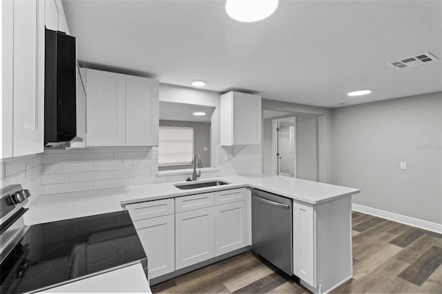 kitchen featuring decorative backsplash, kitchen peninsula, stainless steel appliances, sink, and white cabinets