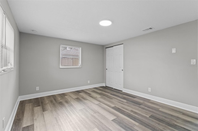 spare room with hardwood / wood-style floors and a healthy amount of sunlight