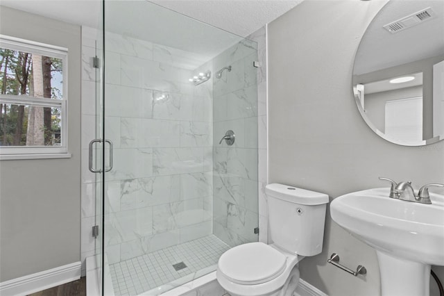 bathroom featuring toilet, an enclosed shower, and sink