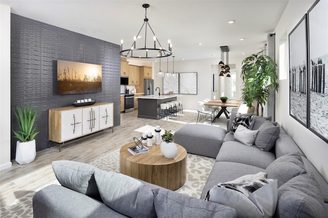 living room with light wood-type flooring, sink, and a chandelier