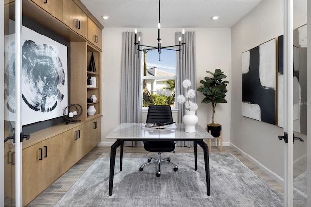 office space with a notable chandelier and light wood-type flooring