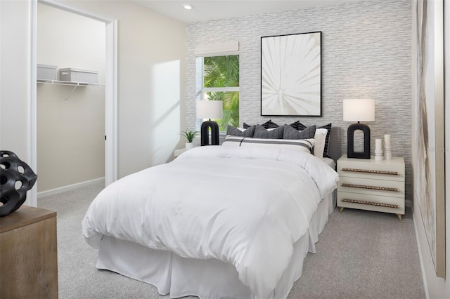 carpeted bedroom featuring a walk in closet and a closet