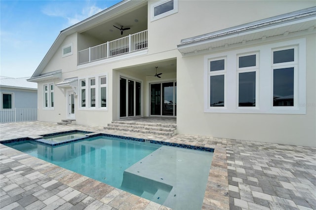 back of property featuring a patio area, ceiling fan, and a swimming pool with hot tub