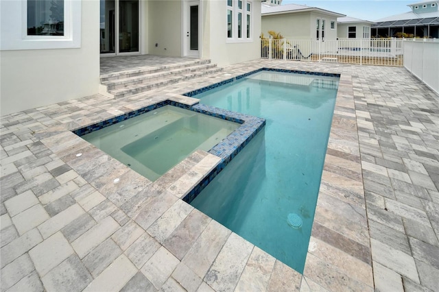 view of swimming pool featuring an in ground hot tub and a patio