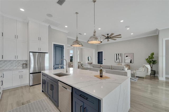 5713 Tybee Island Dr, Apollo Beach, FL 33572 - kitchen featuring appliances with stainless steel finishes, a sink, white cabinets, crown molding, and recessed lighting