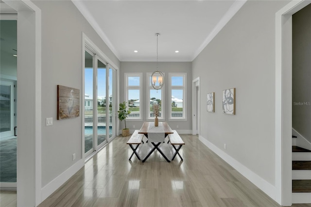 dining room featuring a notable chandelier, light hardwood / wood-style floors, crown molding, and a wealth of natural light