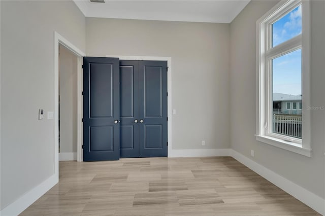 unfurnished bedroom with light wood-type flooring and a closet