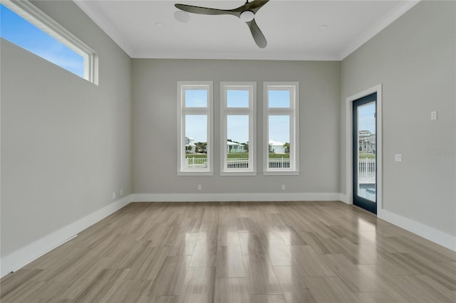 spare room featuring a wealth of natural light, light hardwood / wood-style flooring, ceiling fan, and crown molding