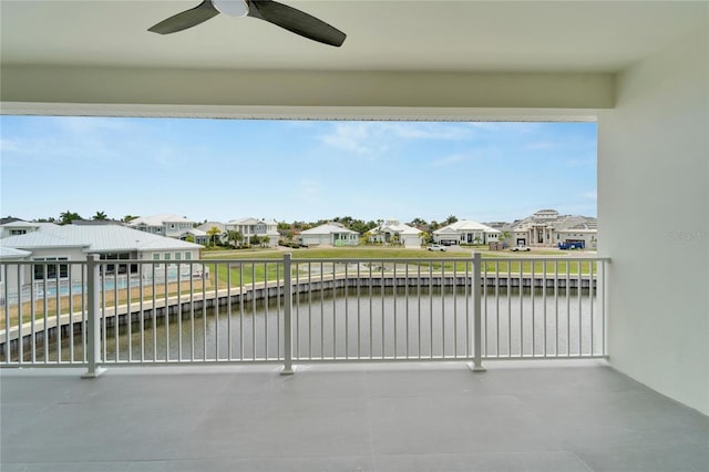 balcony featuring ceiling fan and a water view