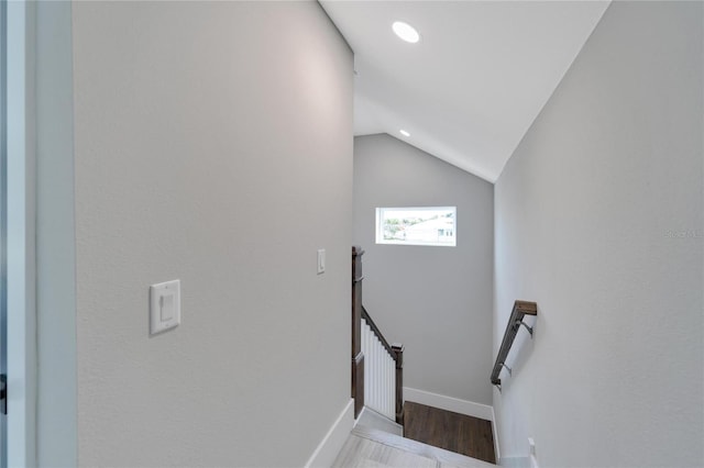 staircase featuring hardwood / wood-style flooring and lofted ceiling